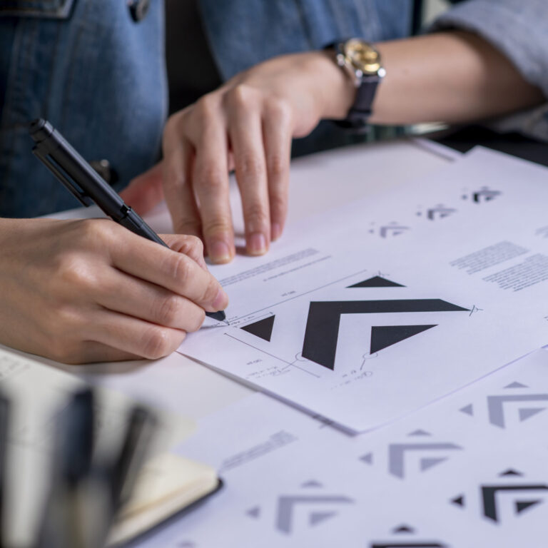 Graphic designer drawing sketches logo design. The concept of a new brand. Professional creative occupation with idea.